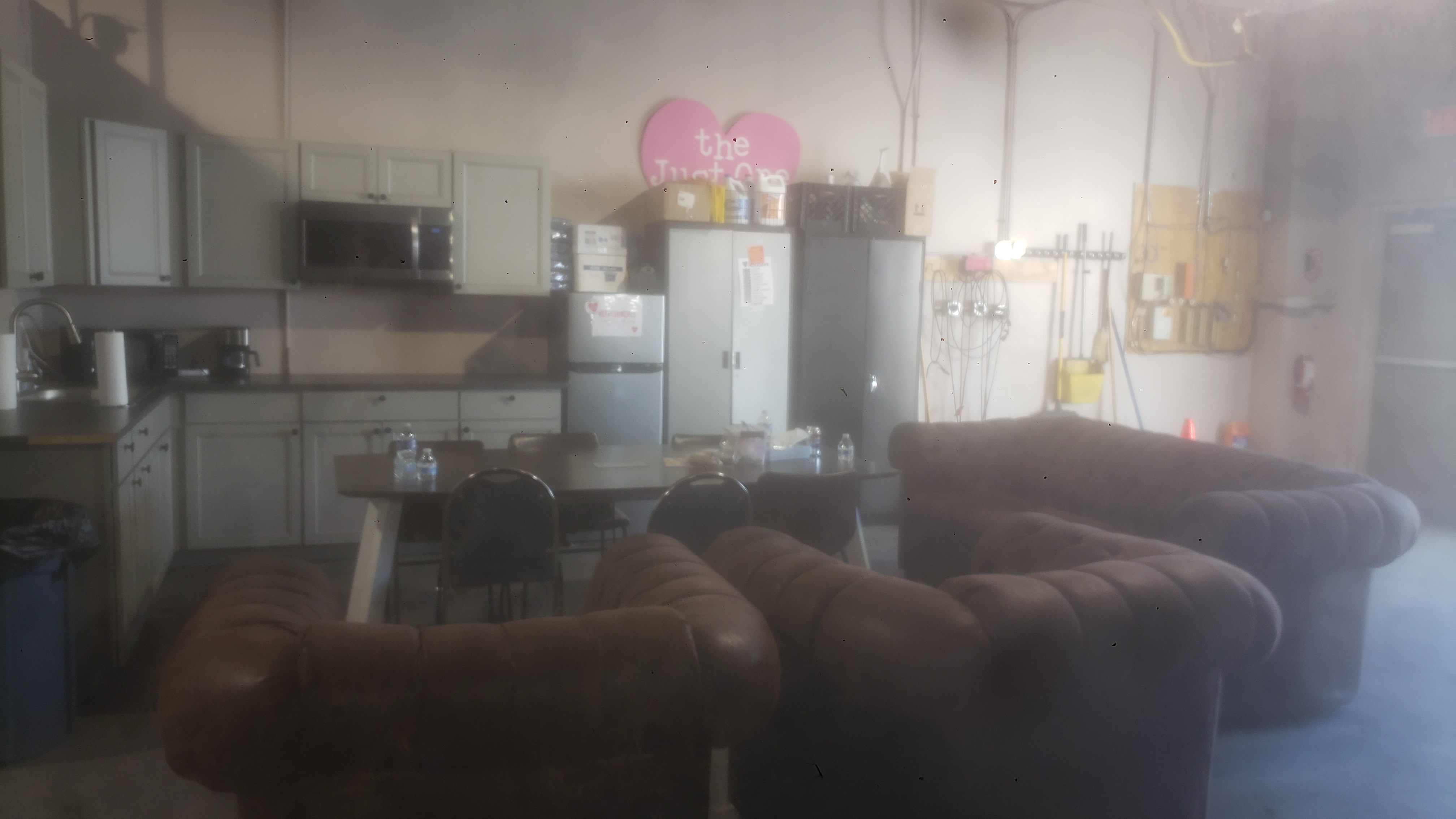 Kichnette with table, couches, and a sign of a heart that says just one project.